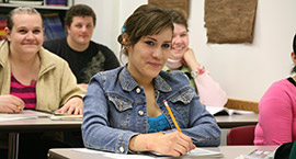 a girl in class,  sitting at a desk